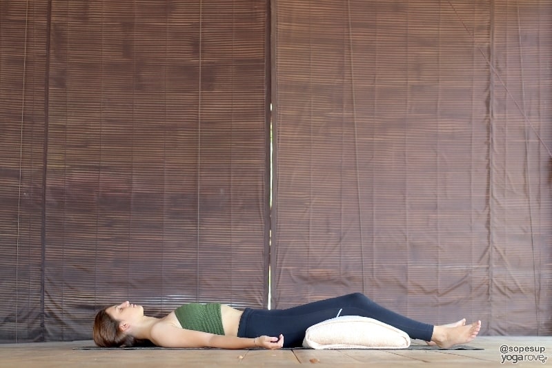 practicing savasana with bolster restorative.