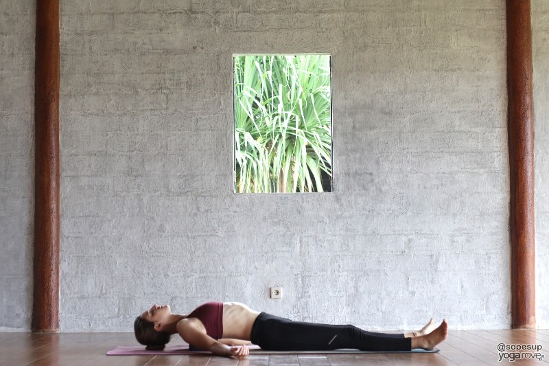 practicing supported fish pose with yoga block