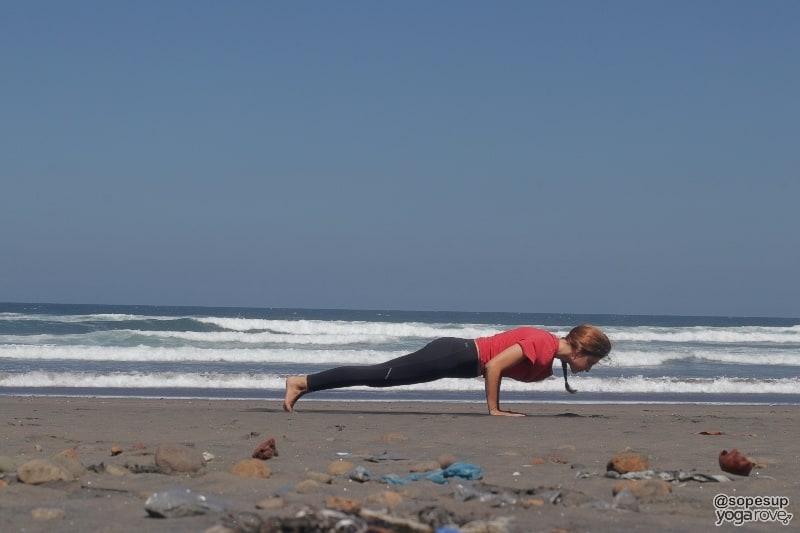 yogi practicing chaturanga on beach