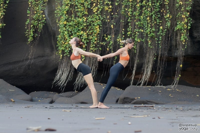 two yogis practicing balancing backbend in partner yoga.