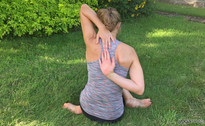 yogi practicing cow face pose for pain between shoulder blades.