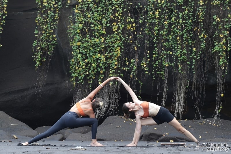 two yogis practicing extended side angle- partner yoga 