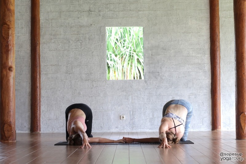two yogis practicing thread the needle pose- partner yoga 