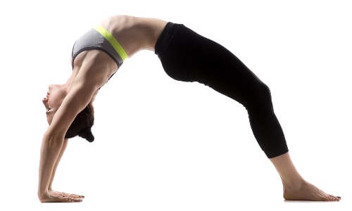 Wheel pose, or Upward Facing Bow, is a great yoga pose to build arm strength. It may look advanced, but there are simple modifications you can do to build up to it.