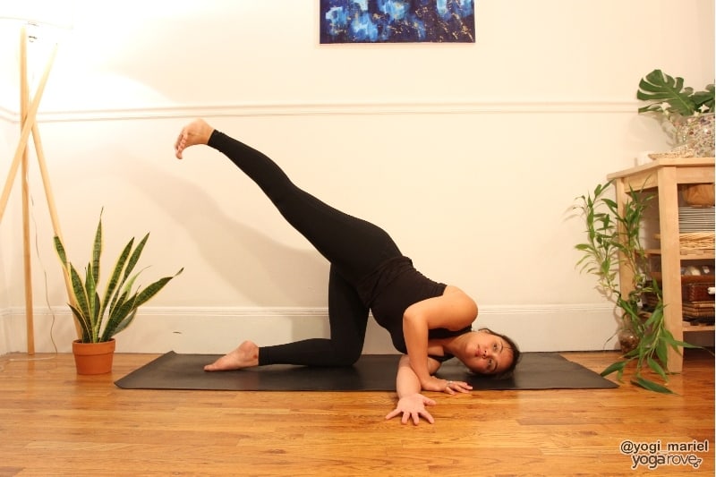 yogi practicing thread the needle balancing variation with leg lifted.