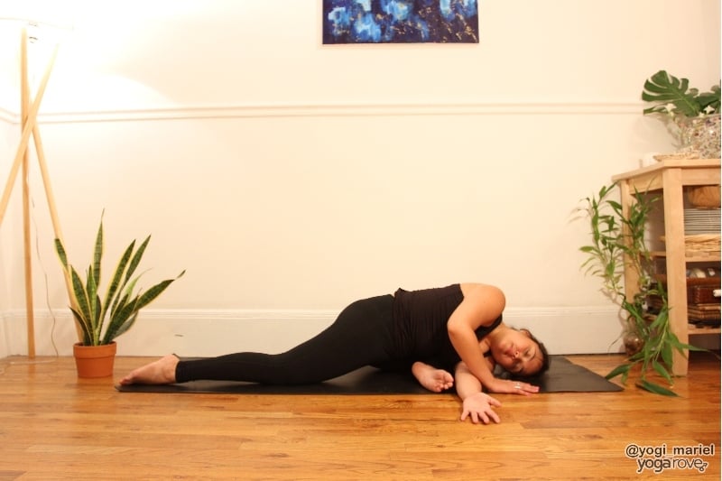 yogi practicing thread the needle pose with pigeon variation