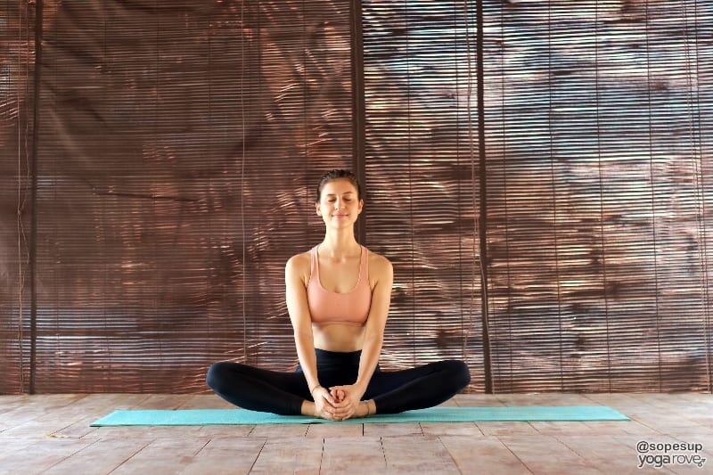 yogi practicing butterfly pose as counter to boat pose.