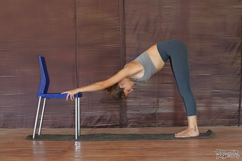 yogi practicing downward facing dog yoga pose in chair.