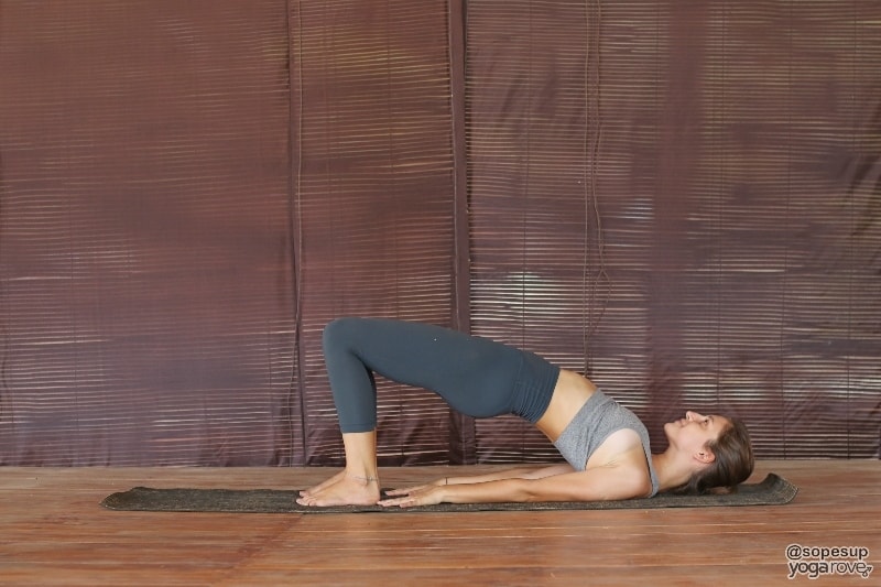 yogi practicing bridge pose on floor for weight loss.