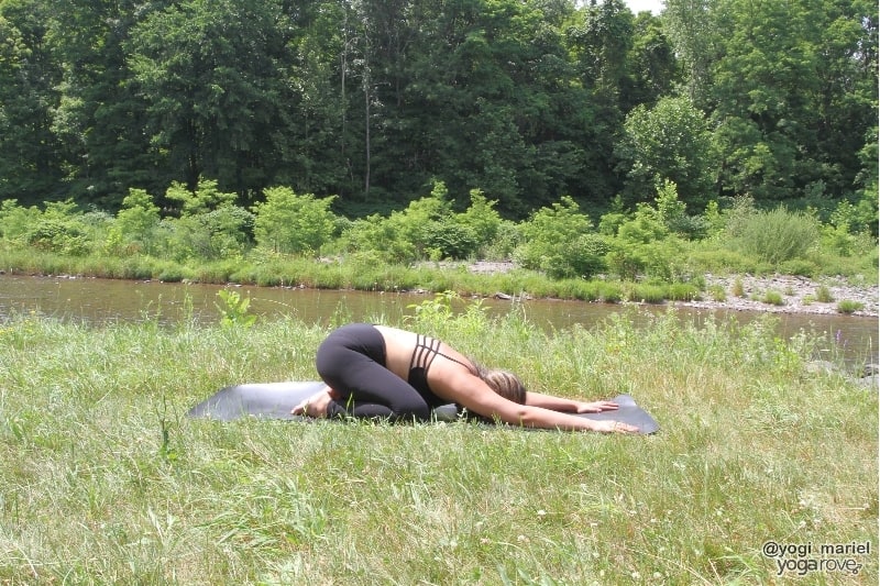 yogi practicing child's pose outside in yin yoga sequence.