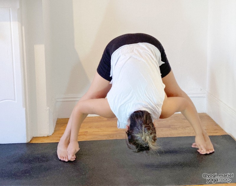 yogi practicing wide legged forward fold to warm up for triangle pose