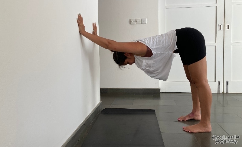 Yogi practicing Downdog on wall 